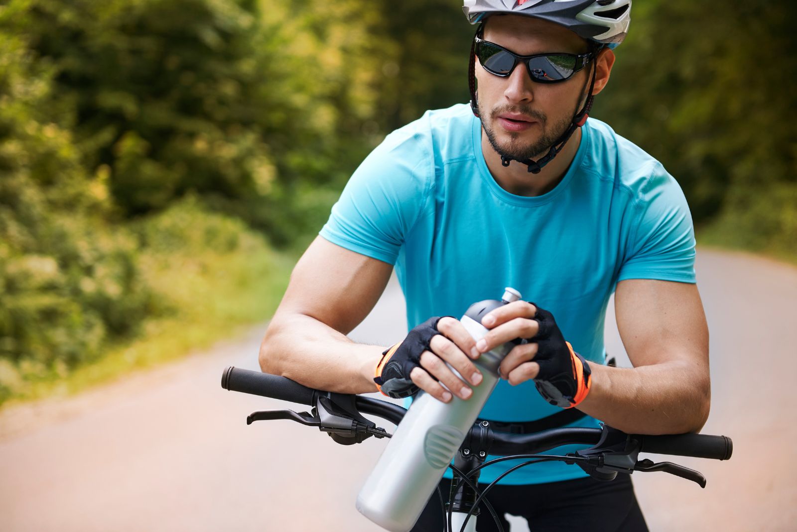 Jak zamontować uchwyt - rowerzysta odpoczywa, siedząc na rowerze i trzymając bidon